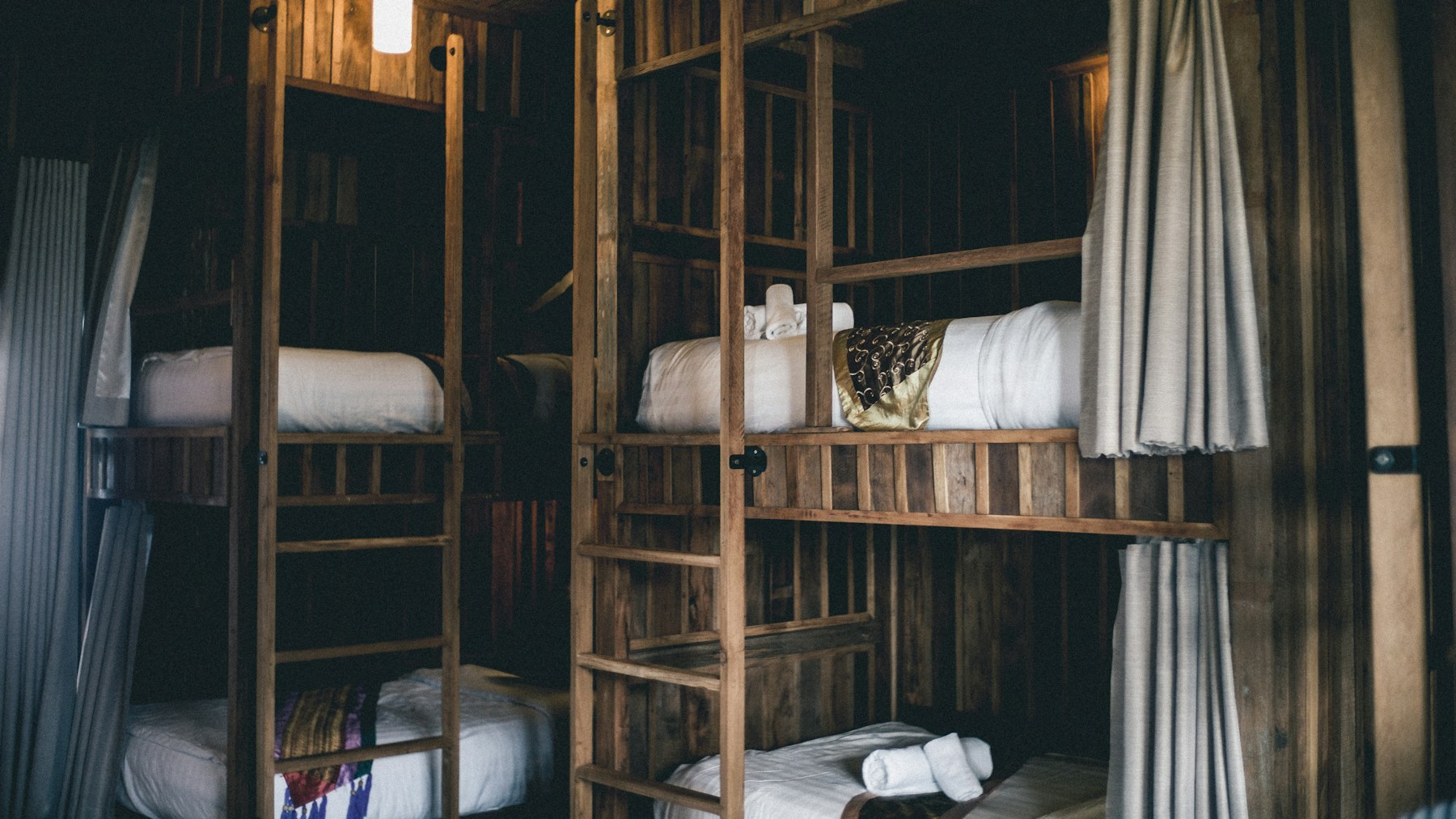 A shared hostel room with wooden bunk beds
